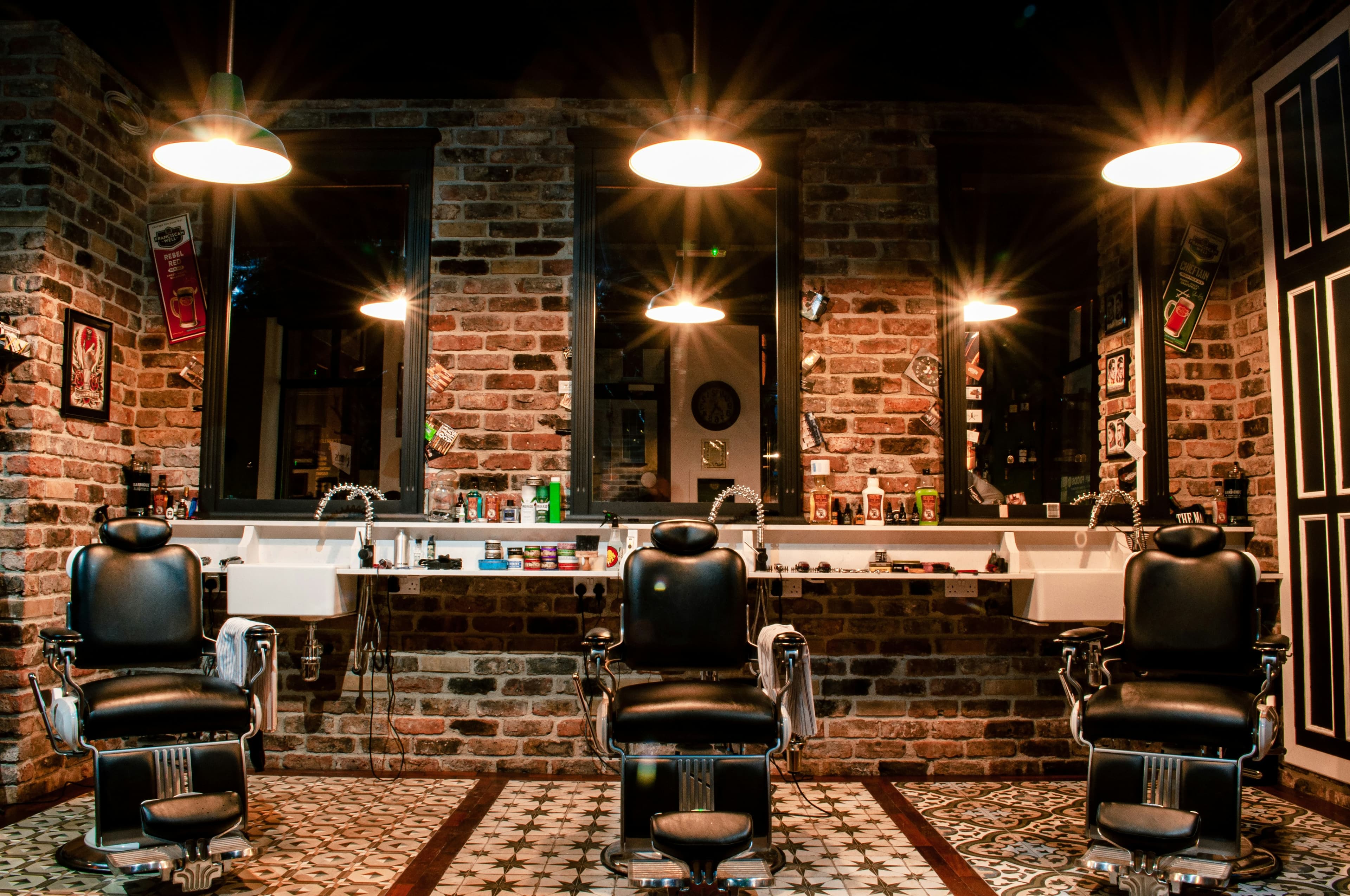 Classic barbershop stations with brick walls and pendant lighting